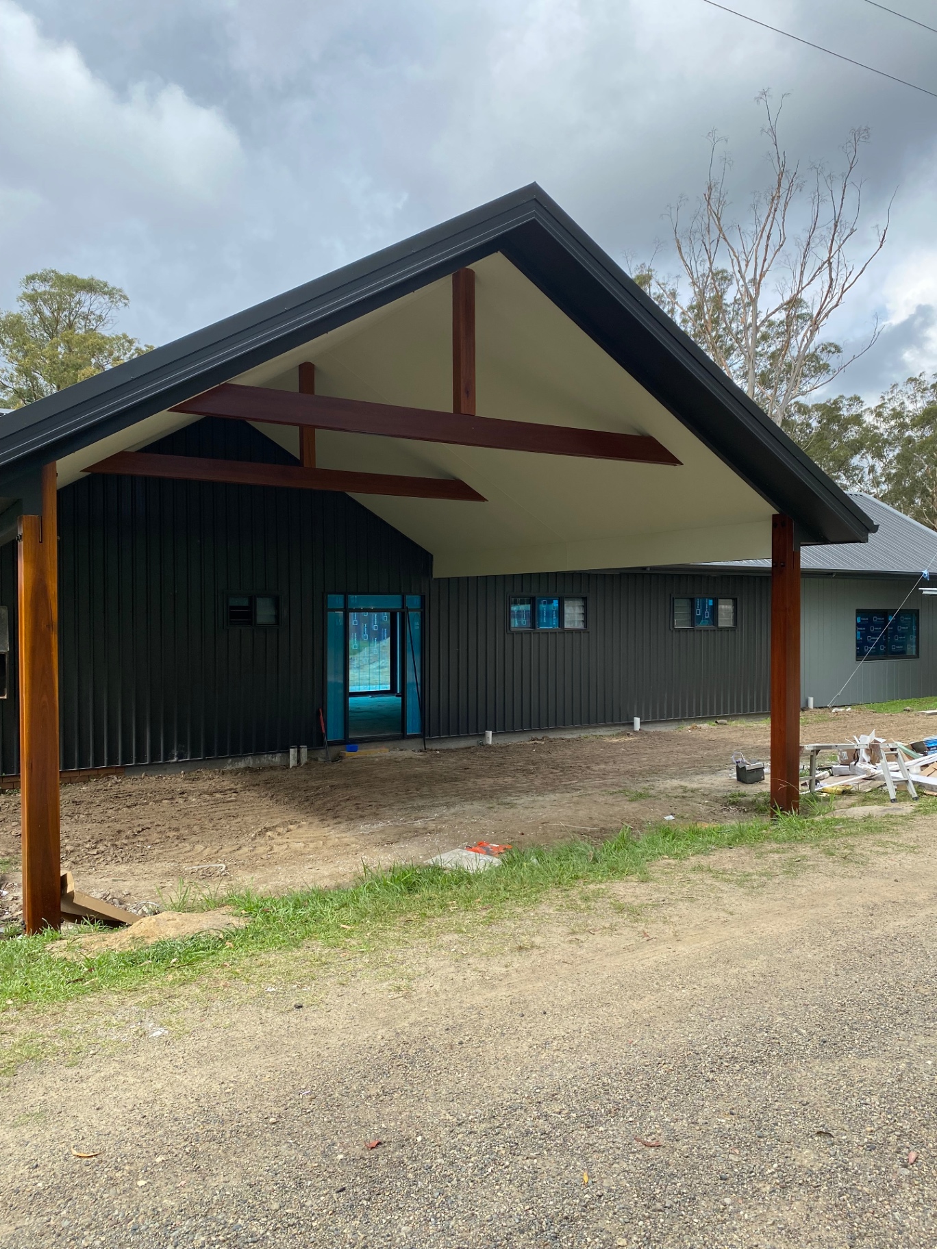 New build at lock up stage with hardwood posts, exposed rafters and vertical cladding