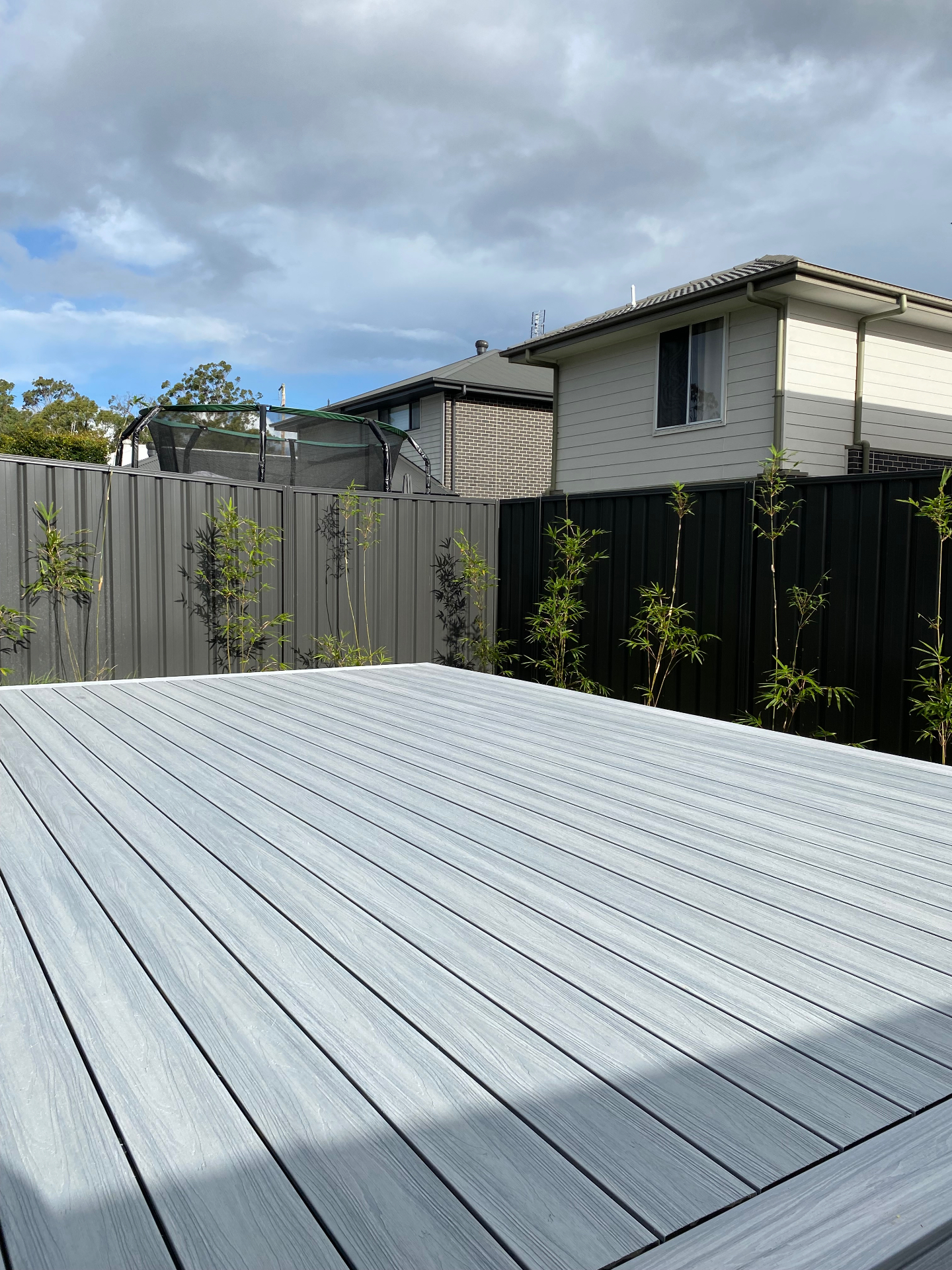 Grey composite deck boards running toward new bamboo screening at the Warnervale home