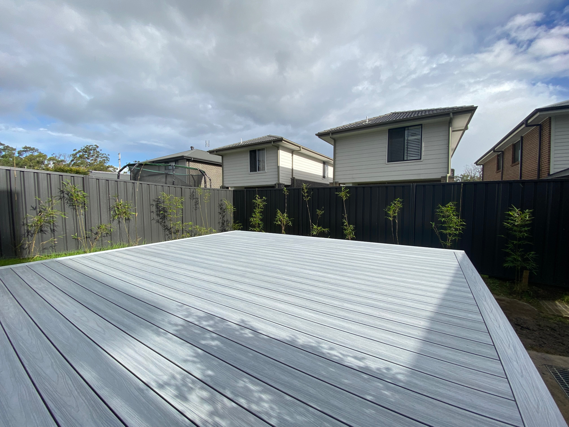 After: finished grey composite deck sitting level across the Warnervale backyard