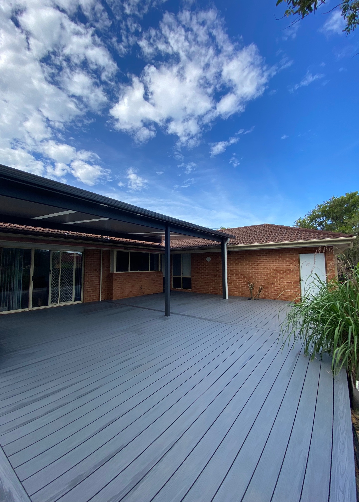 After: wide composite deck and insulated flyover pergola across the rear of the Chittaway Bay home