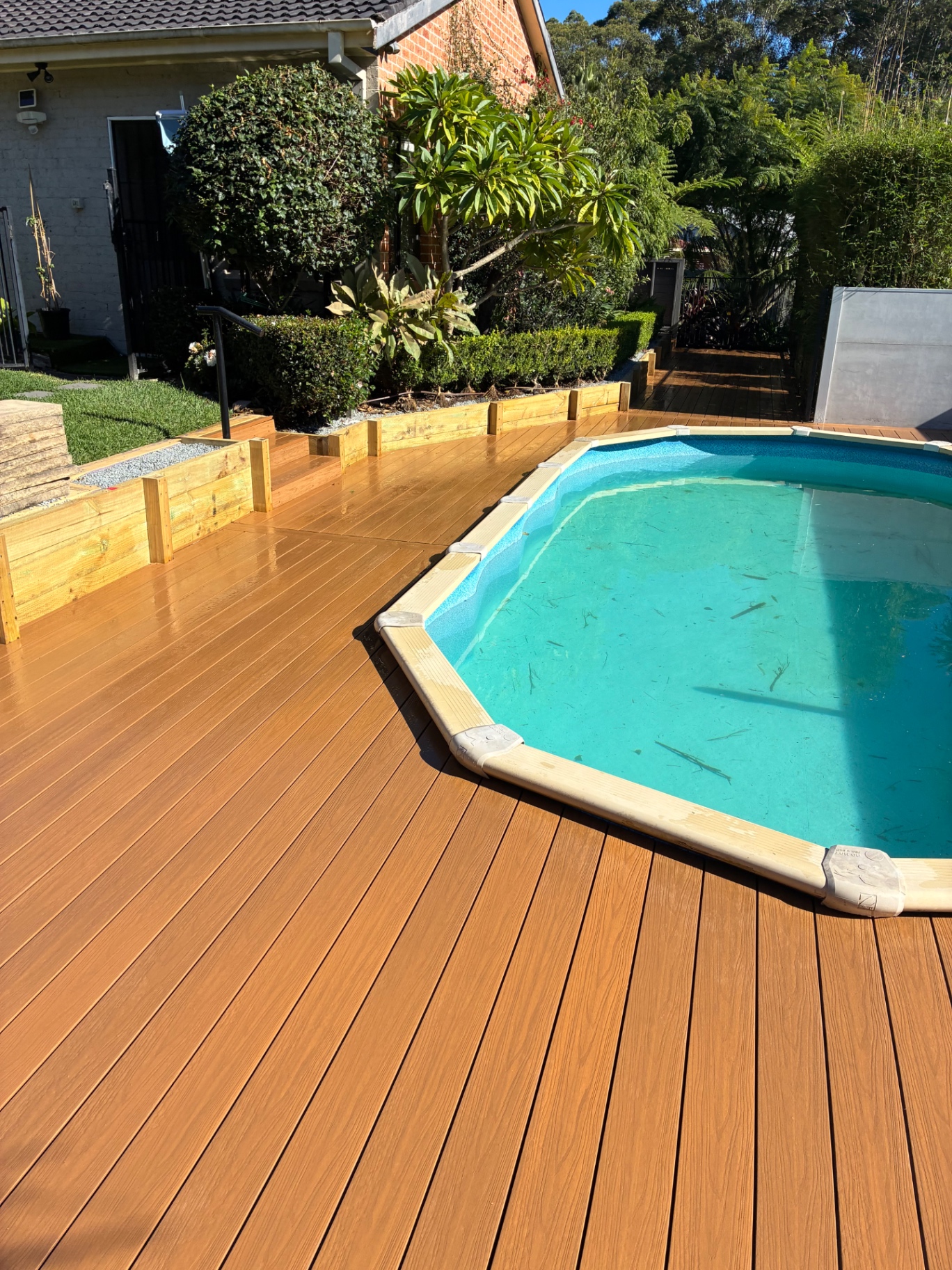 After: warm Ekodeck composite boards running flush to the pool coping with new garden edging
